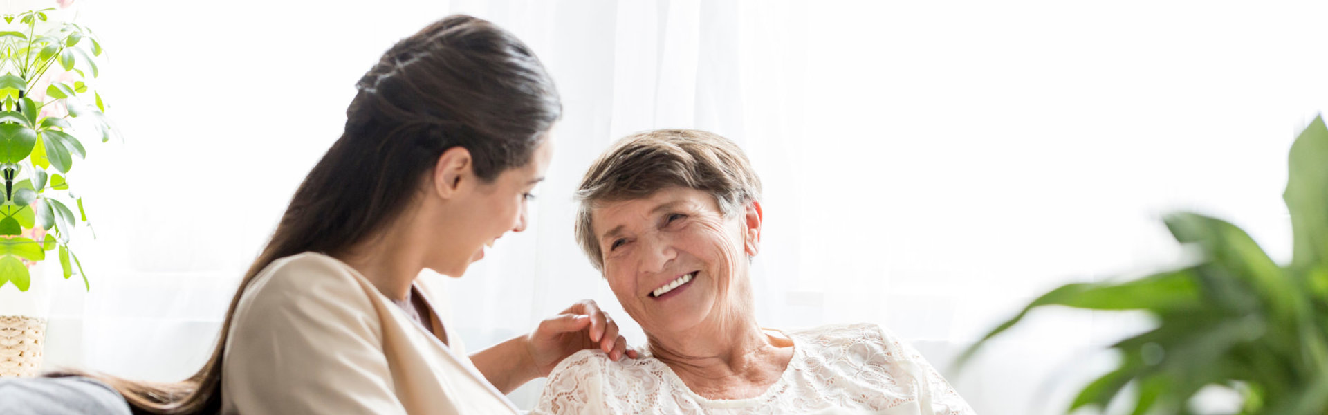 Woman talking to an elderly woman on the couch