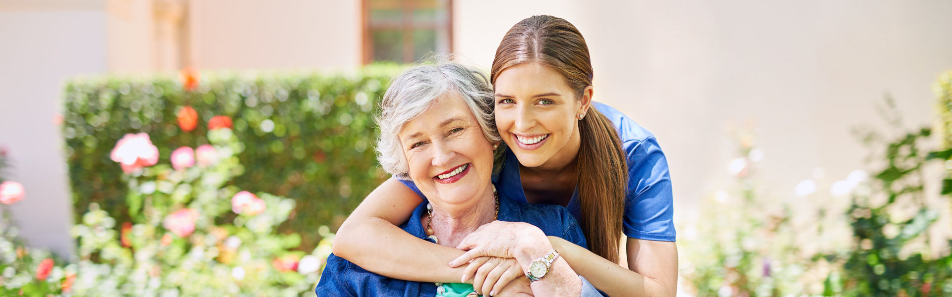 Shot of a resident and a nurse outside in the retirement home garden.