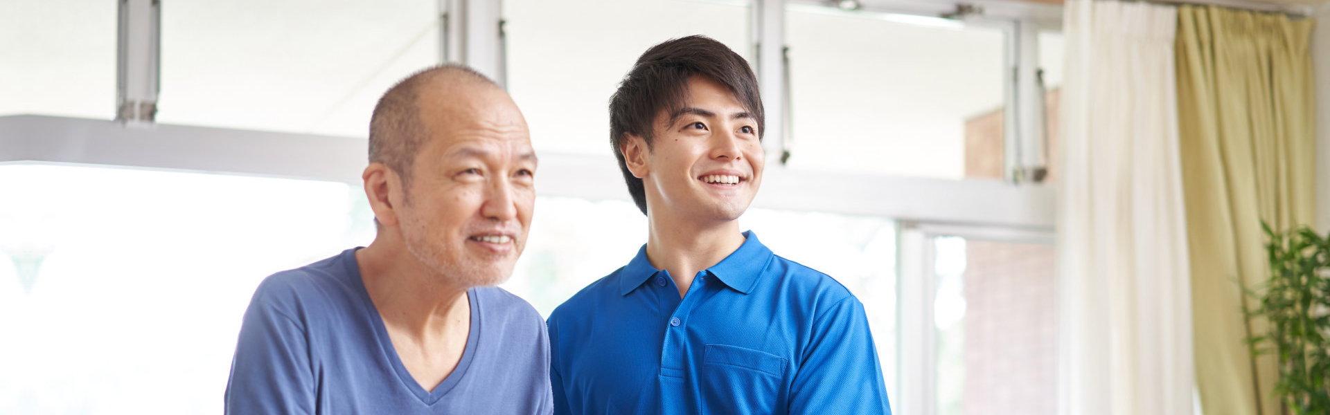 Young man assisting the elderly man to walk