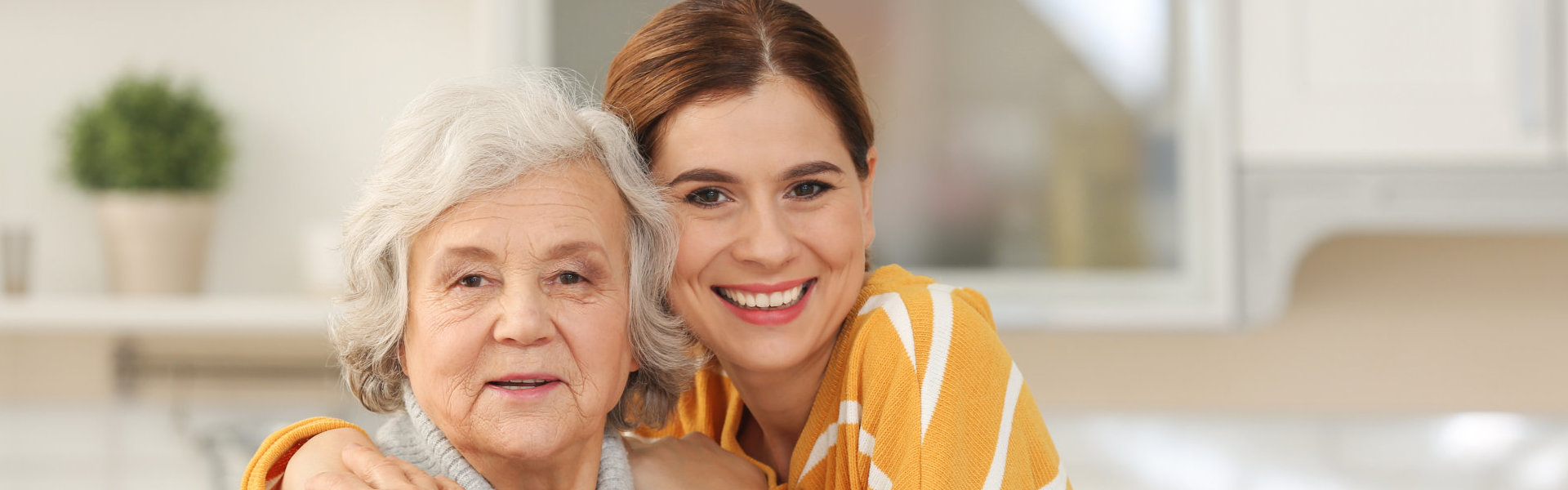 Elderly woman with female caregiver in kitchen